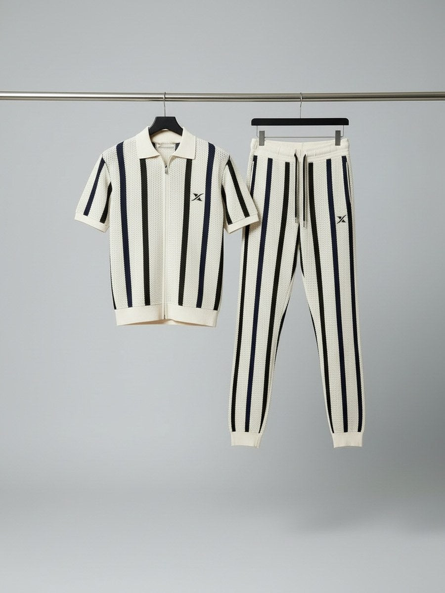 A zip-up polo in cream and navy striped knit and its matching joggers, hanging on a workshop rail